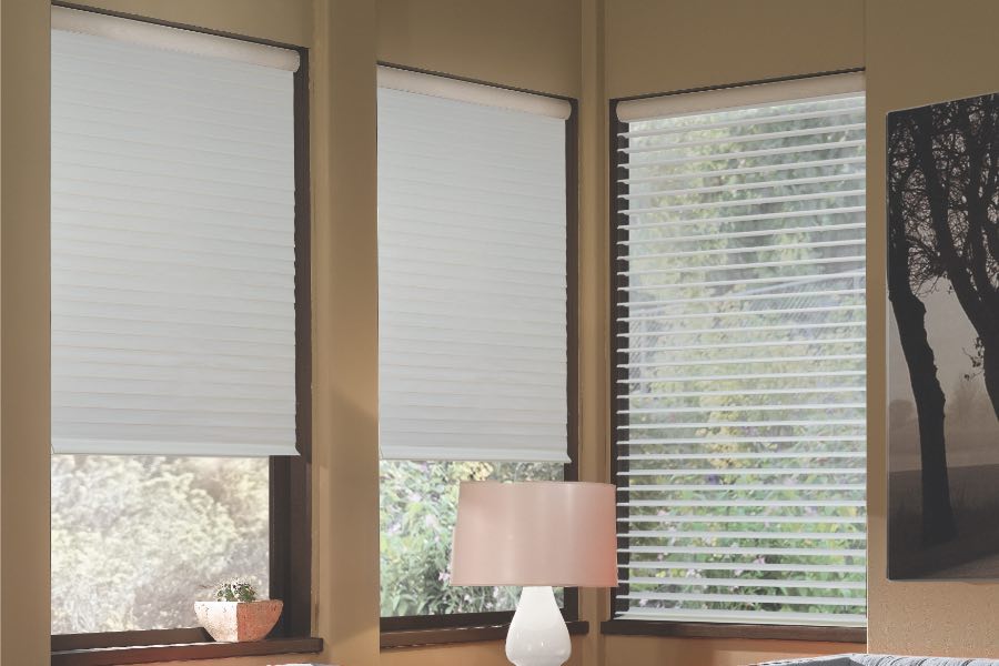 Opaque motorized window shades in Fort Myers keep hot UV rays out of your home. Gray motorized sheer shades on corner windows next to gray furniture
