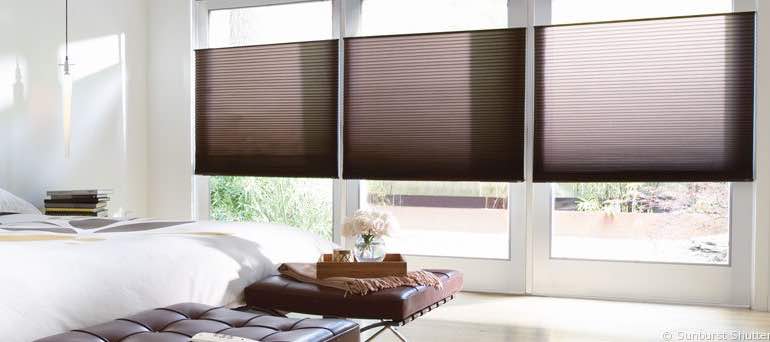 Chic Fort Myers bedroom with high ceiling windows and vertical honeycomb shades.