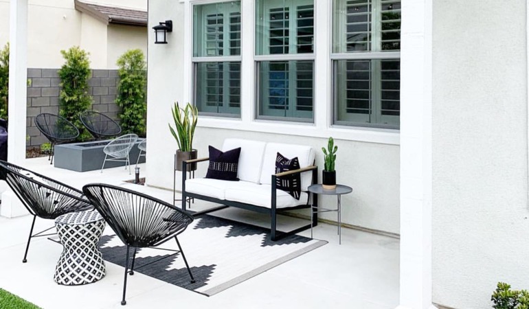 An outside patio with plantation window treatments