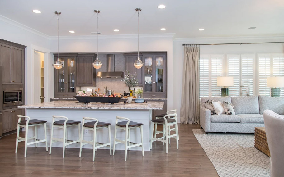 Illuminate your home with custom interior shutters in Fort Myers. White arched shutters in a white kitchen with lots of light.