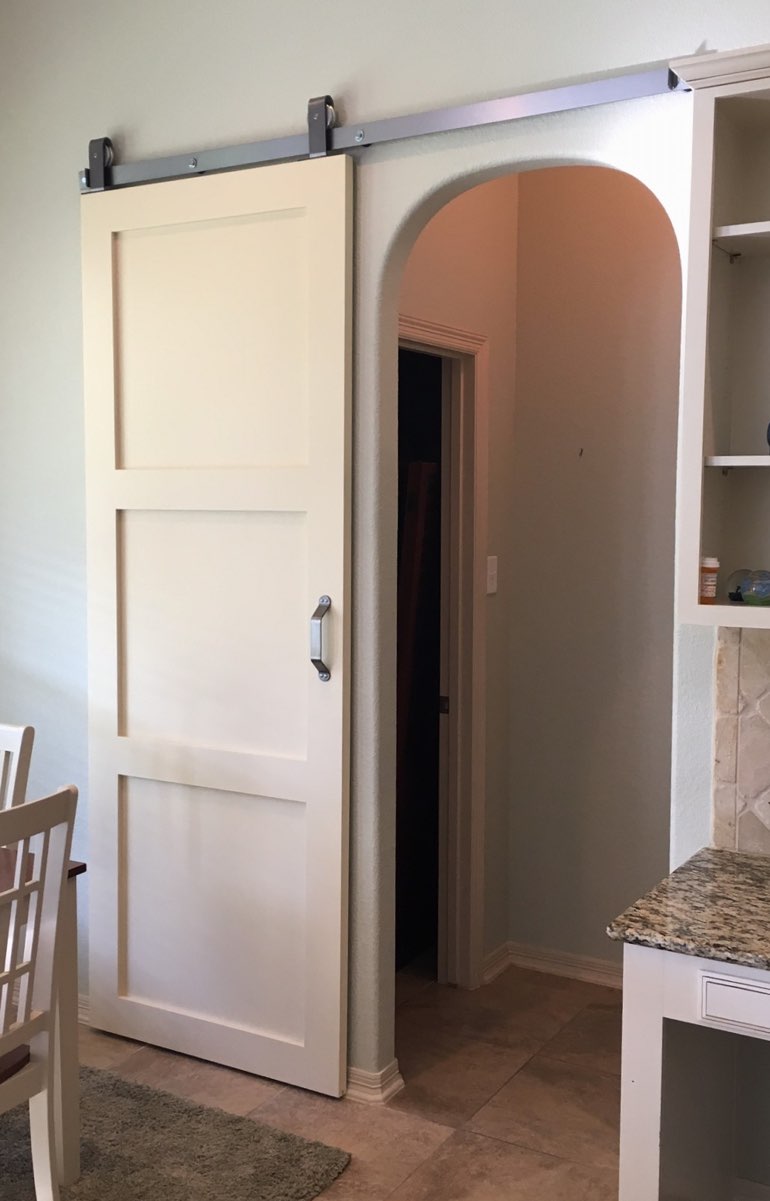 Sliding barn door on dark track used for bedroom door