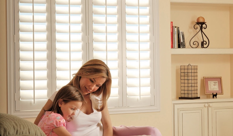 Easy to clean Polywood shutters are perfect cord-free options for kids. Mom and daughter in front of window
