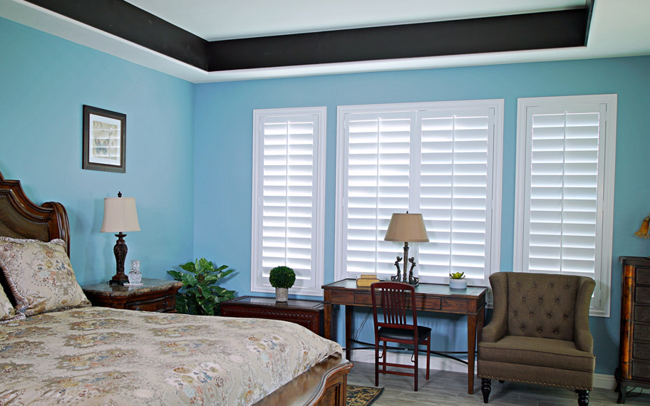 Polywood shutters provide insulation for the perfect temperature all year long in Fort Myers. Polywood shutters in a bedroom.