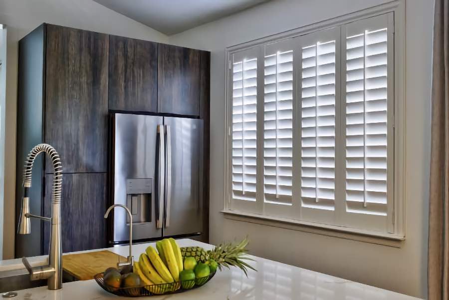 Homeowners use indoor window shutters in Fort Myers when they want attractive and functional window treatments. Polywood shutters on a large kitchen window