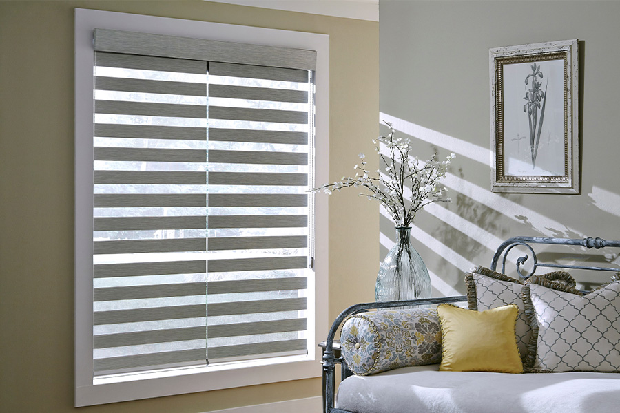 Find Practical and stylish window blinds for Fort Myers homes at Sunburst. Gray blinds on a large window next to a couch.