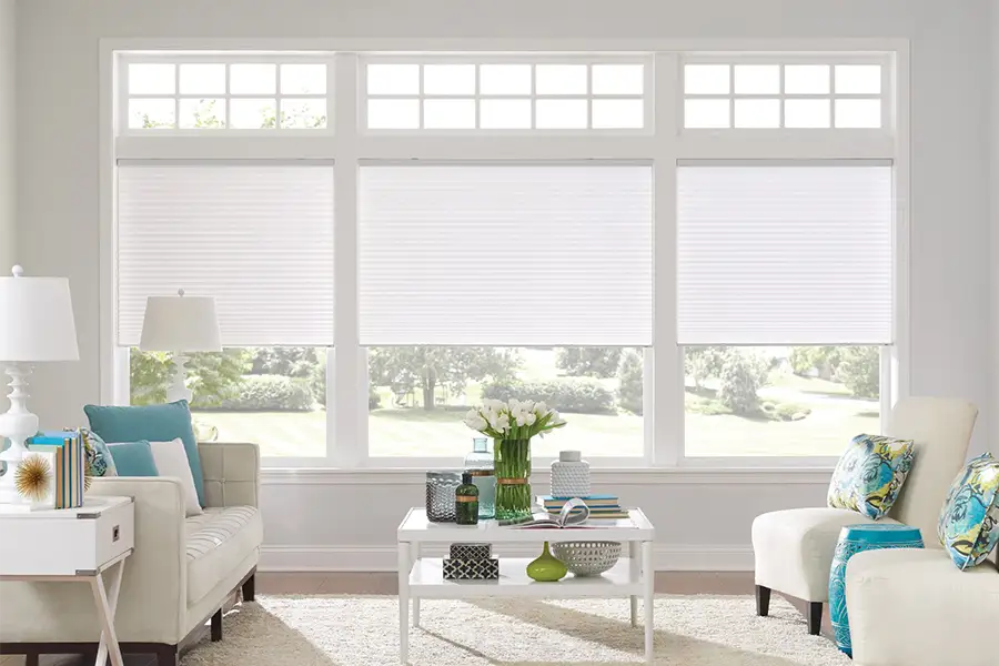 Insulating cellular shades can help keep cold air and hot UV rays from entering your Fort Myers home. White cellular shades on windows in a white living room
